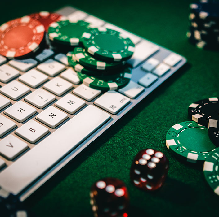 Computer keyboard next to casino chips and dice