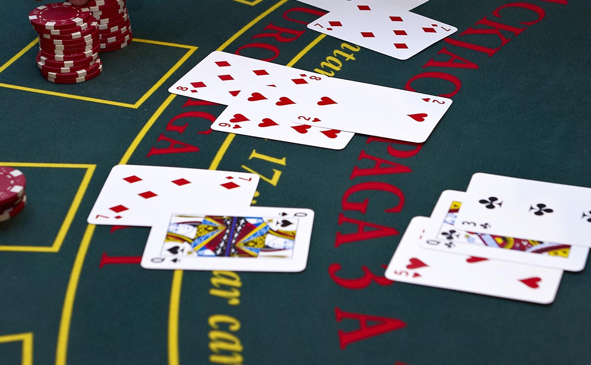 Mesa de blackjack con las manos de los jugadores y el crupier
