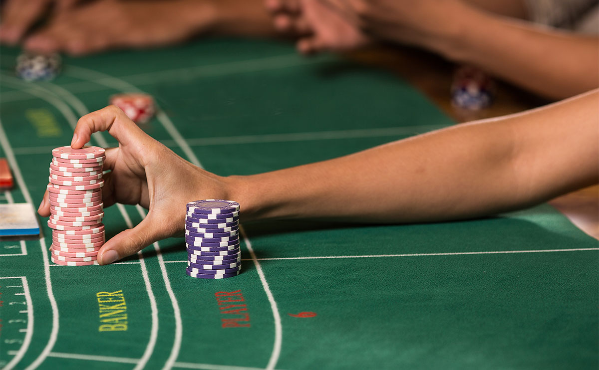 Jugadores haciendo apuestas en una mesa de punto y banca