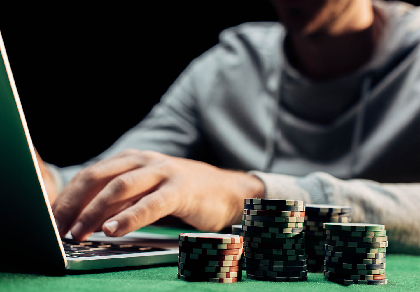 Jugador usando su ordenador junto a fichas de poker
